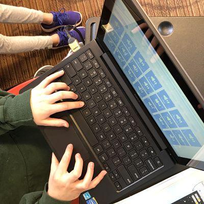 child typing on a computer 