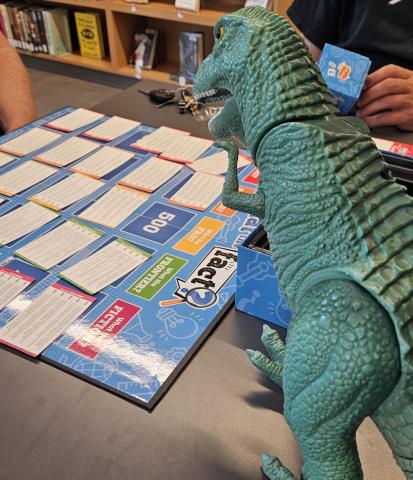 Dinosaur toy playing a board game