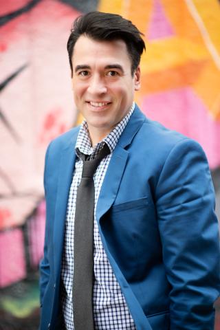 Photo of young adult author Byron Graves in a suit and tie.